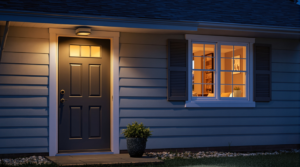 Well-lit home exterior with reinforced front door and secure windows at dusk.